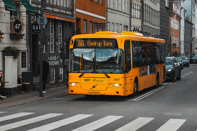 yellow and black bus at the stoplight with a scrolling LED sign