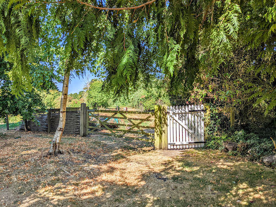 Follow the byway past a bench on the right to a white gate