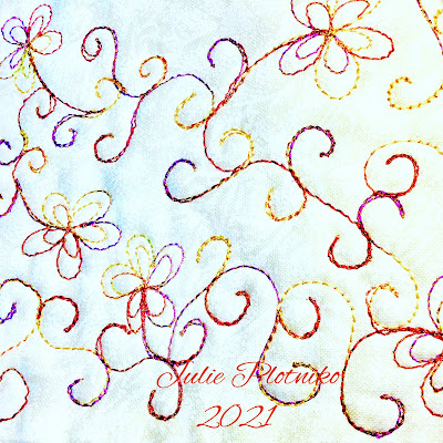 A free motion quilting design of flowers and swirls