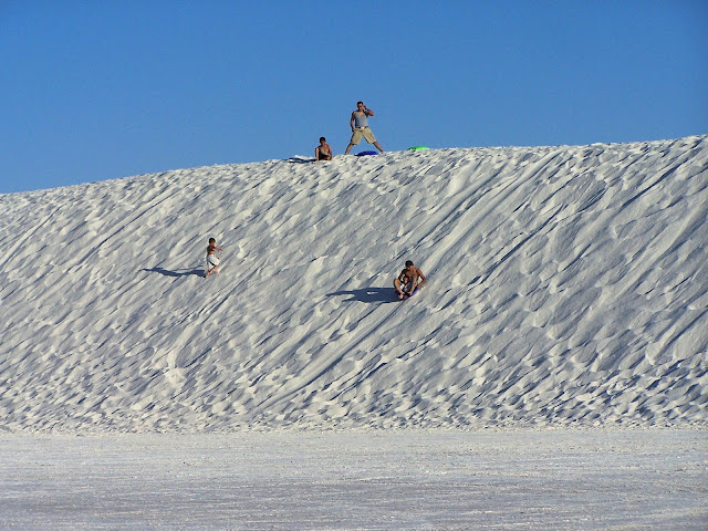 Des gens qui font de la luge dans la sable blanc :D