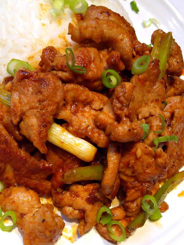 Korean Spicy Pork! A super simple stir-fry recipe with thinly sliced pork tenderloin, sriracha, soy sauce and other common ingredients perfect over rice or in lettuce wraps.