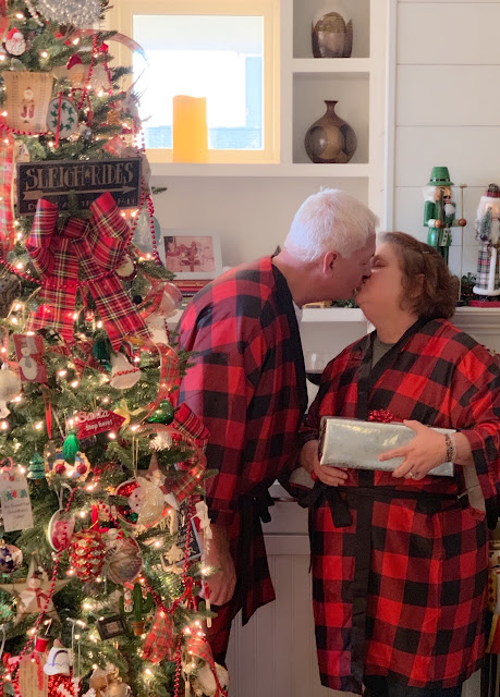 Christmas tree, man and woman kissing in matching buffalo plaid pajamas