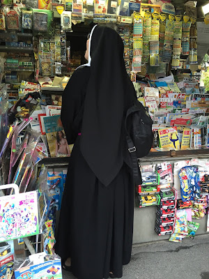 A polish nun at a newsstand in Bergamo