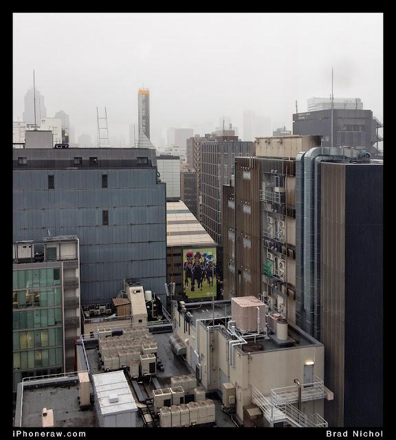 Ginza from 9th floor in Typhoon with rain showing tops of buildings and foggy sky.