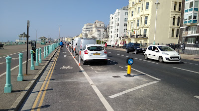 A view of the cycle lane with a car parking bay to its right.