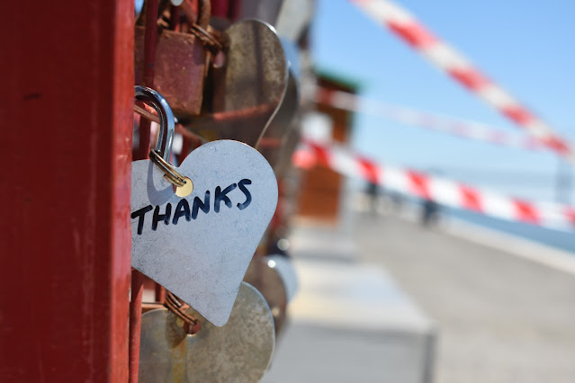 heart shaped lock on gate with many other locks that says thanks