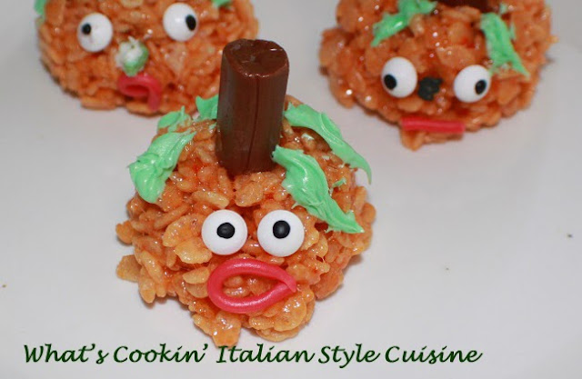 Halloween orange rice krispies pumpkin heads with tootsie rolls centers. These are a traditional recipe for rice krispie treats.