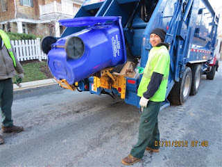 Recycling crew emptying a paper recycling cart into its truck