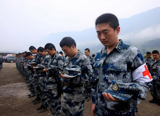 Rescue soldiers remove their hats to mourn for the victims of the Lushan April 20 earthquake.