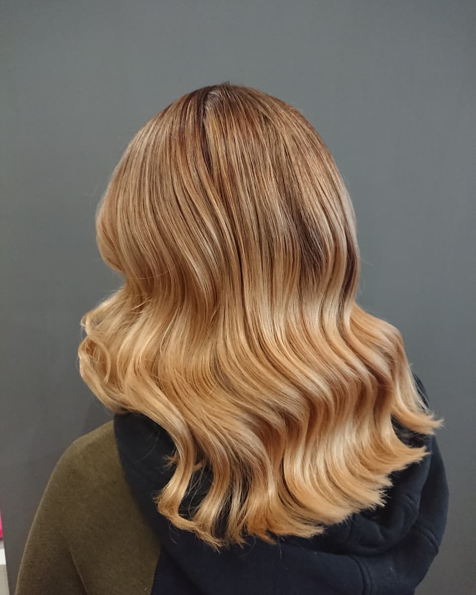 achieve polished and shiny hair with golden sandy blonde waves for classic look