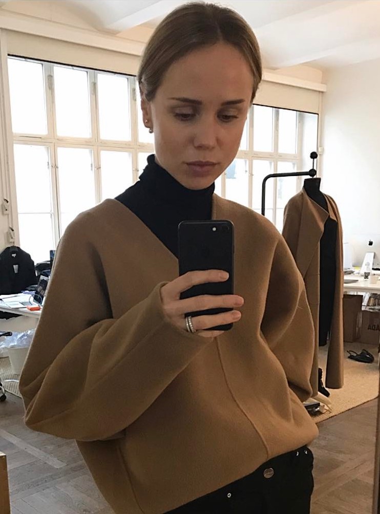 How to Wear a V-Neck Sweater Like a Swedish It Girl — Elin Kling in a camel Toteme sweater and black turtleneck sweater