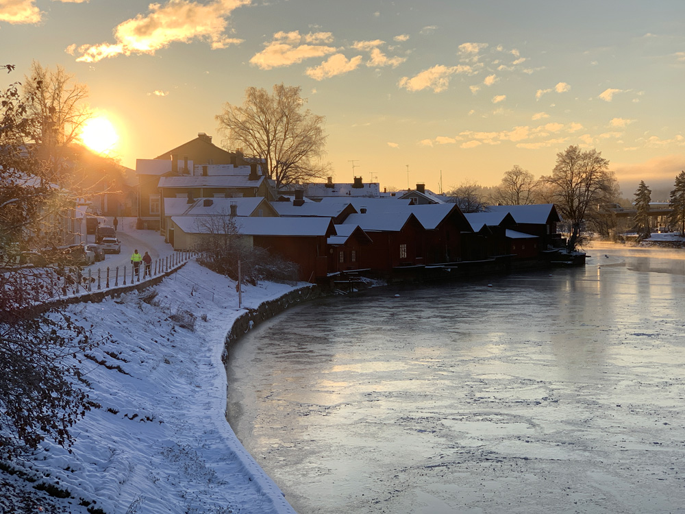 Two men walking at sunset by the river