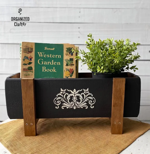 Photo of newly painted & stenciled flower box with a faux plant & vintage garden books