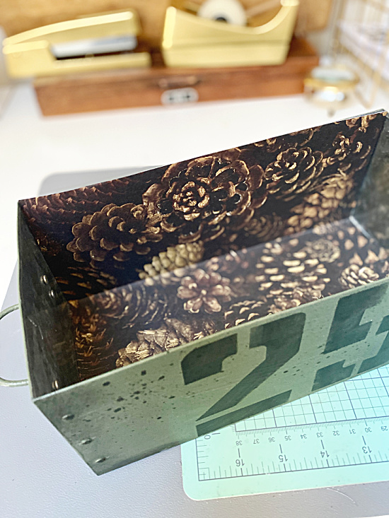 metal crate with pinecone paper inside