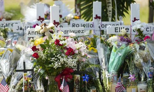A makeshift memorial at Robb Elementary School is filled with flowers, toys, signs, and crosses bearing the names of all 21 victims of the mass shooting that occurred on May 24