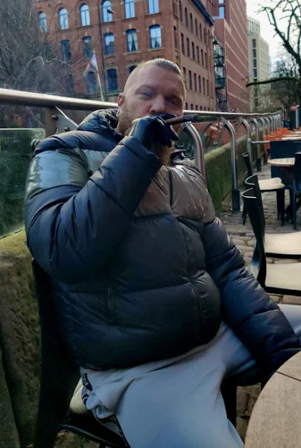 Puffy Leather jacket Scally biker sits on bench puffing stogie