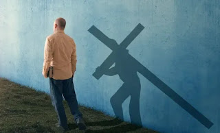 hombre con Biblia en mano cargando la cruz