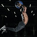 Man jumping in mid air holding blue ball above his head