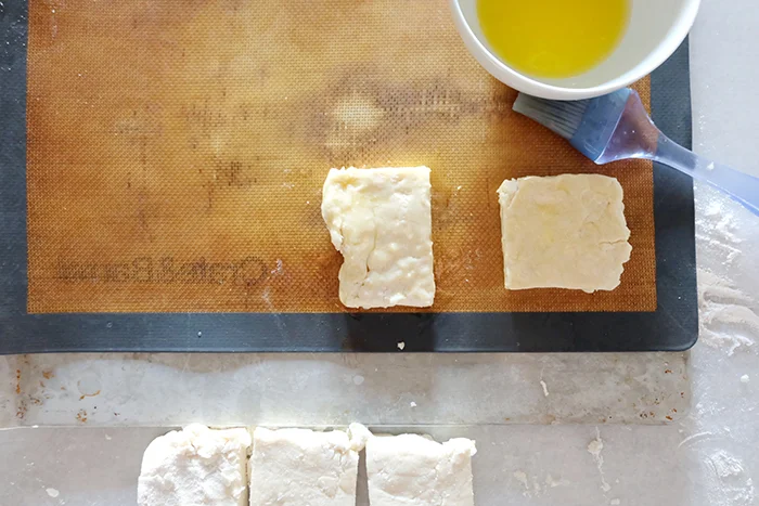 brushing biscuit dough with butter