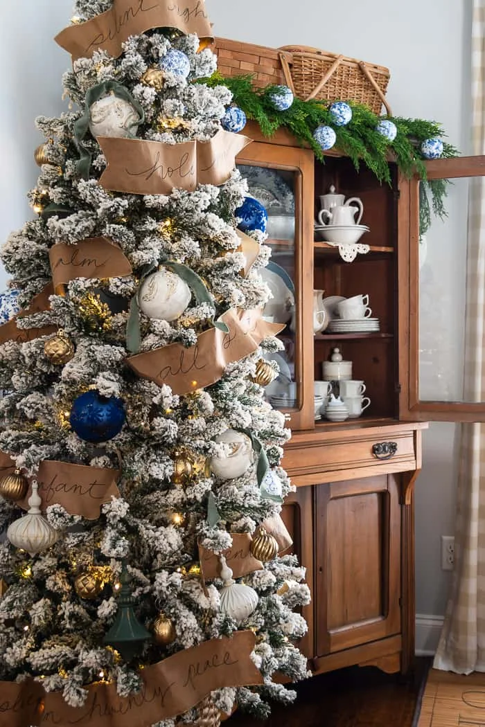 neutral Christmas tree, pops of blue, kraft paper song lyric ribbon