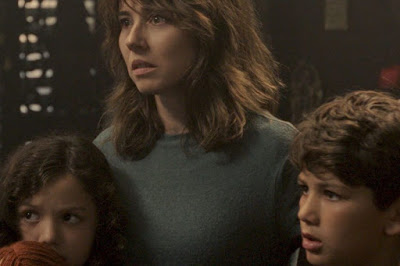 Movie still for The Curse of La Llorona (2019) where Linda Cardellini embraces her children and protects them from a horror movie villain