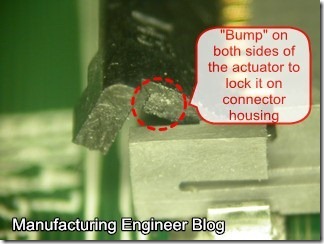 Right angle connector with bump show on both actuator sides of connector to lock it on the housing.