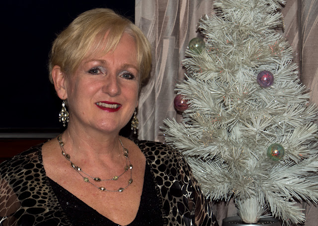 Photo of me with our little tree before the marina Christmas dinner