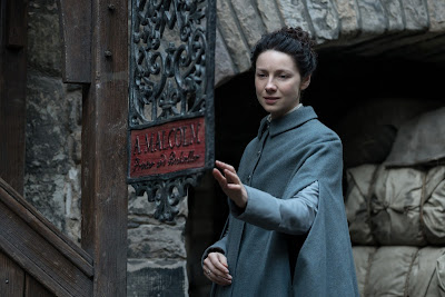 Claire llega a la puerta de la imprenta de Jamie en el 3x05 de Outlander