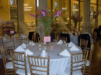 The centerpieces were tall trumpet vases with hot pink gladiolus with bronze