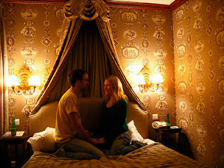 Imagen de un hombre y una mujer sentados en una cama 