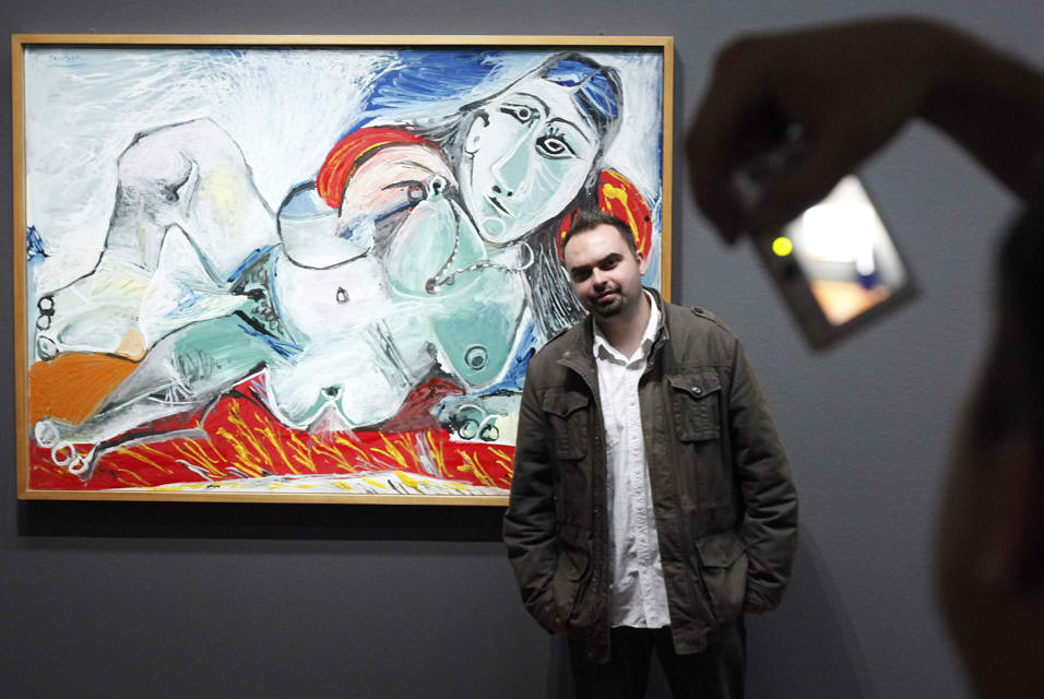A man passes a large photograph of Pablo Picasso at the Albertina Museum in 