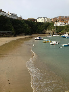 looking across the beach in Newquay. Several boats can be seen moored in the shallow water