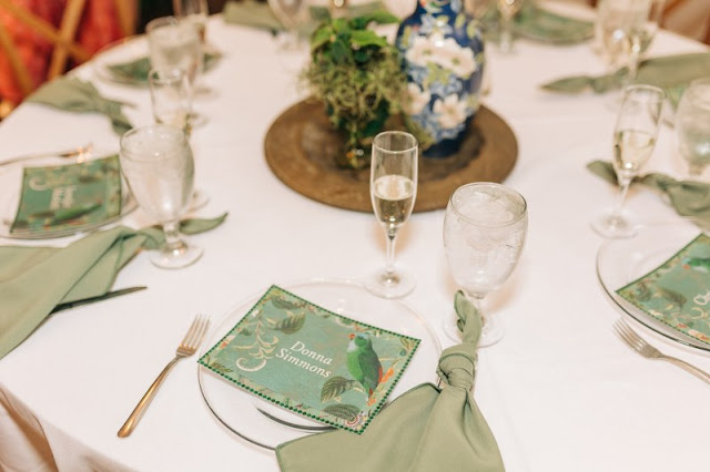 reception table setup with sage green knotted napkin and green menu