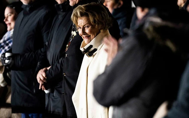 Queen Sonja wore a white peplum jacket and white cashmere cape. Queen wore a brown blazer suit