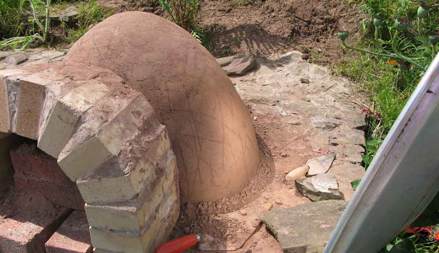 Drying the dark side of the clay oven by reflecting the sun.