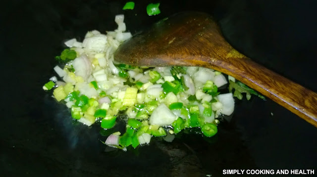 Onion and chili is frying in a wok