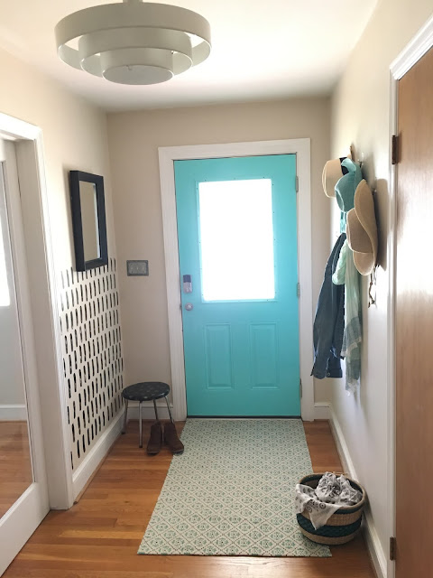 Update a boring entry way with a bright door and hand painted accent wall using a sponge! 