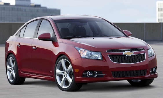 Front 3/4 view of red 2011 Chevrolet Cruze parked on rooftop garage