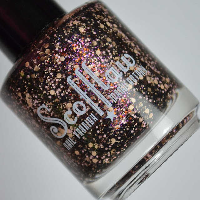 black nail polish with peach and pink glitter in a bottle
