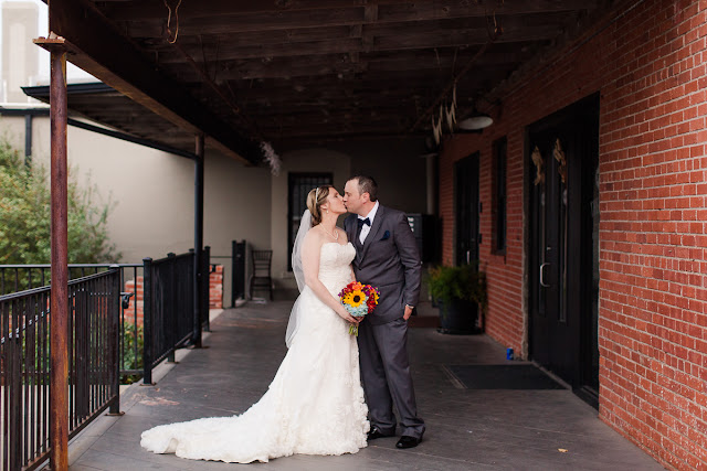 A quick kiss during the formal portraits.  Because they had a First Look, their pictures are being taken before the ceremony, allowing them to immediately join the reception following.  Therefore, they are not quite husband and wife yet, but they are pretty close!  Set at the Hall at the Railhouse located in Norman, OK during the fall of 2016.