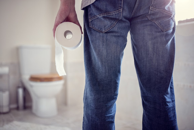 Man Holding a Toilet Roll in the Bathroom - Renovation Kingdom