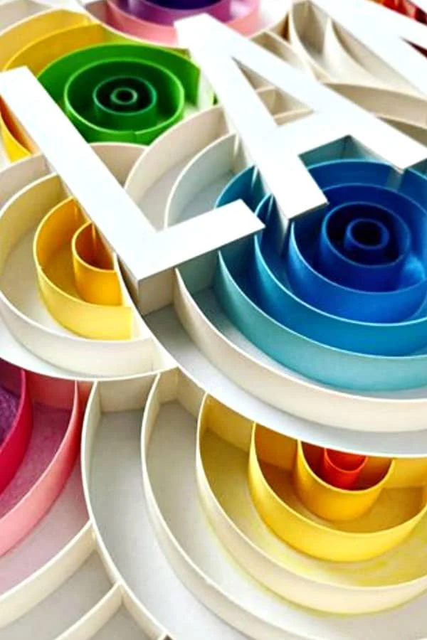 on-edge colorful circular paper art with paper cut block letters