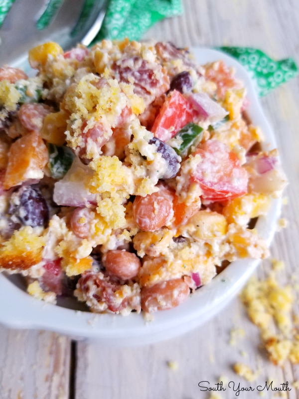 Confetti Cornbread Salad! A kaleidoscope of crisp bacon and diced fresh vegetables, creamy beans and shredded cheese tossed with sour cream dressing and crumbled cornbread in a bright, beautiful, fun salad perfect for potlucks, picnics and Sunday dinner.