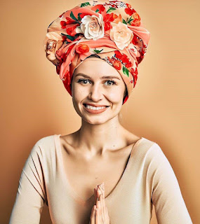 woman wearing flower headwrap smiling with joy on her face