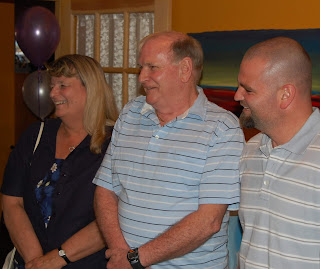 Paula, Tod, and Trevor Eaton standing in a row, looking to their right.