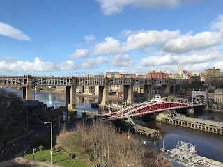 View from Gateshead over the Tyne to Newcastle showing the High Level Bridge and the Swing Bridge.  The Swing Bridge is red and white with what looks like a small lighthouse in the centre.  Photograph by Kevin Nosferatu for The Skulferatu Project.