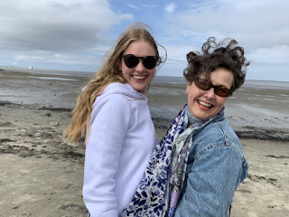 Moeder en dochter met waaihaar op het strand van Delfzijl