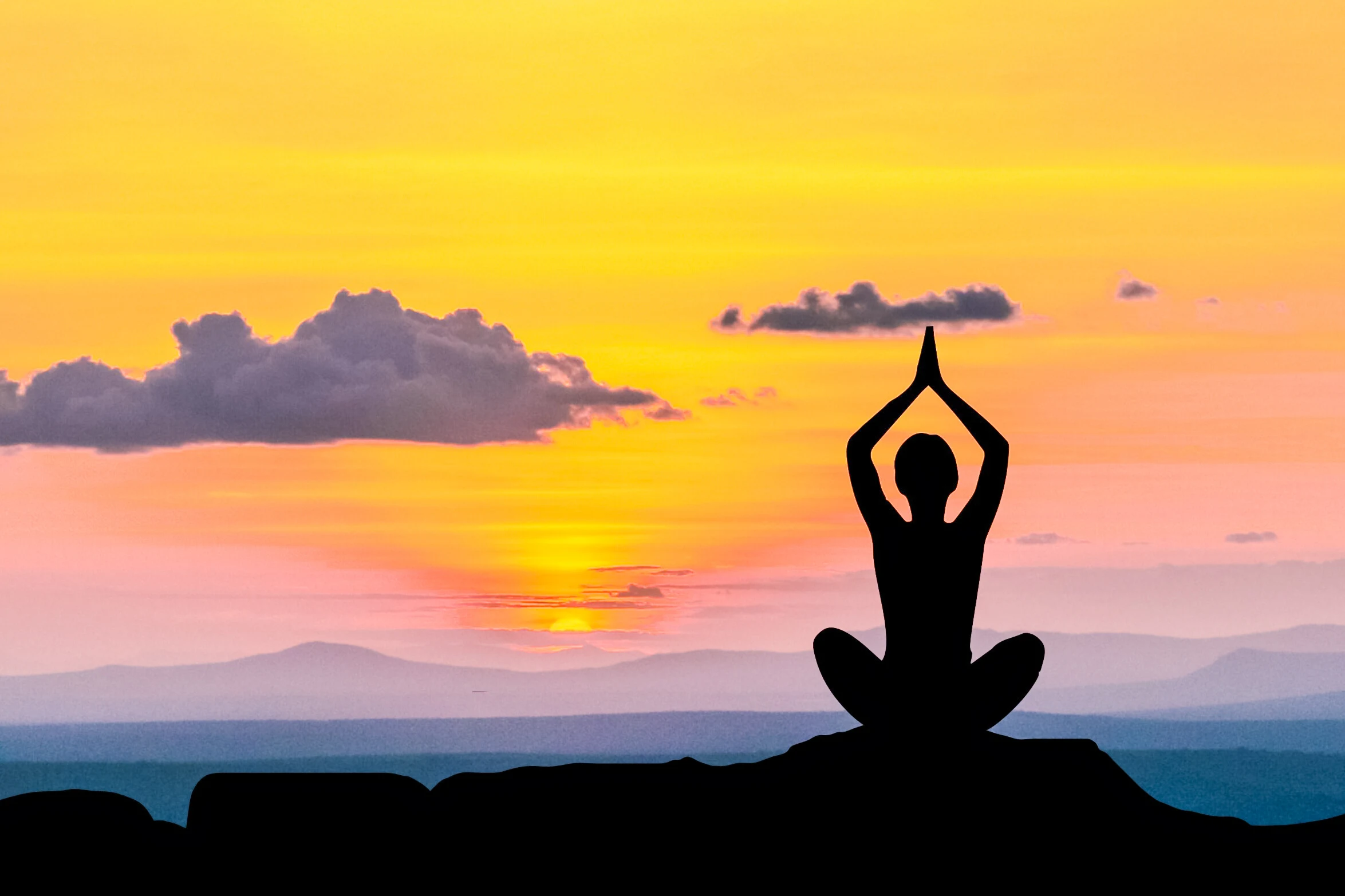 A woman practicing yoga at sunrise, illustrating a holistic approach to mental well-being.