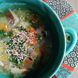 Sopera azul con sopa de verduras y setas con sésamo y perejil