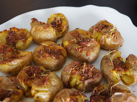 Patatas machacadas después de una primera cocción al vapor, y acabadas al horno con un aromático aliño mediterráneo.